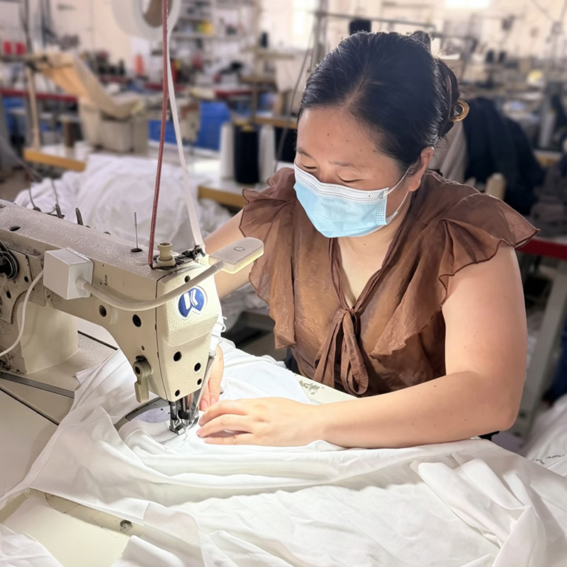 Custom Clothing Manufacturer worker sewing custom garments on production line